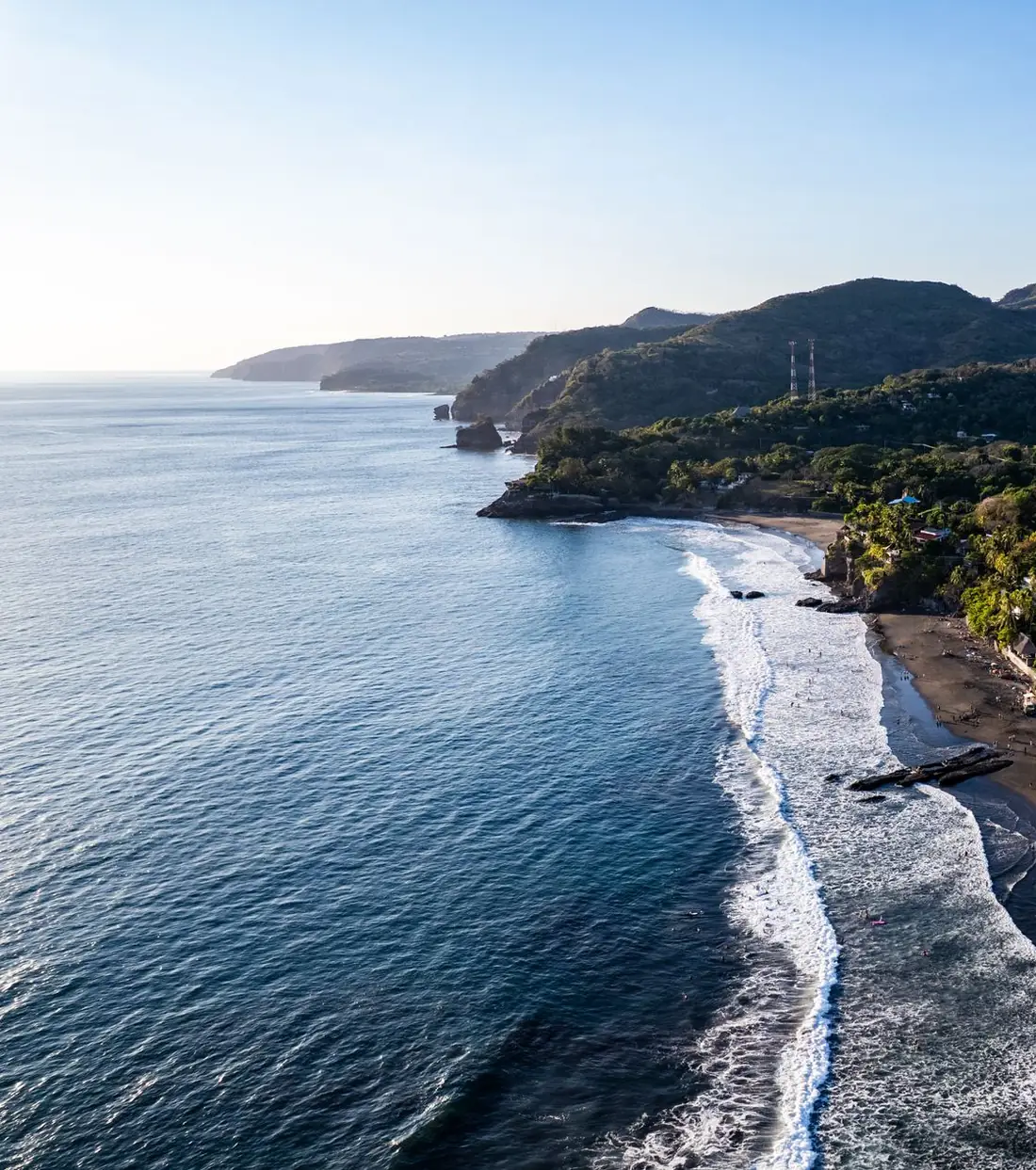The Pacific coast near El Zonte in El Salvador from above, with surf and green hills